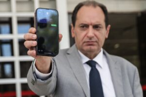 Ο πρώην υπουργός Χρήστος Σπίρτζης δείχνει το κινητό του με τα παγιδευμένα μηνύματα